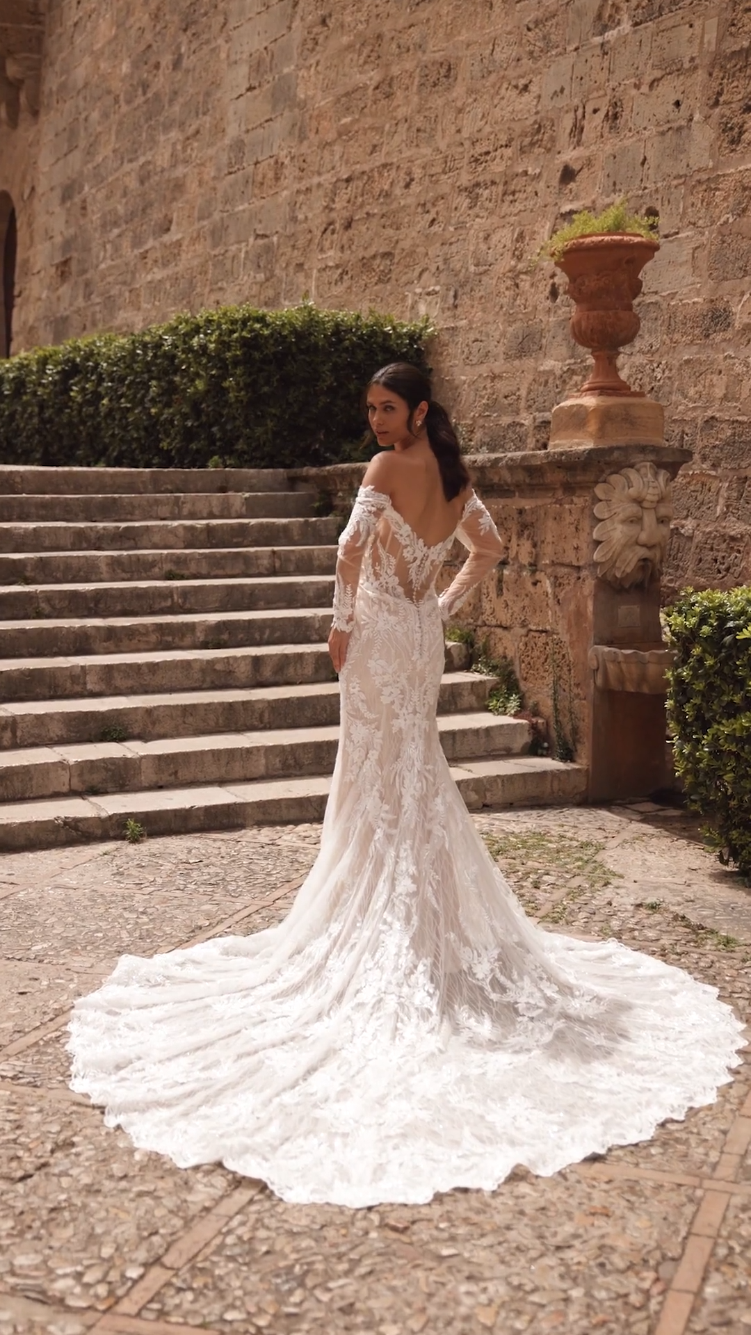 Sparkle and lace wedding dress with off the shoulder long sleeves and pointed leaf shaped train